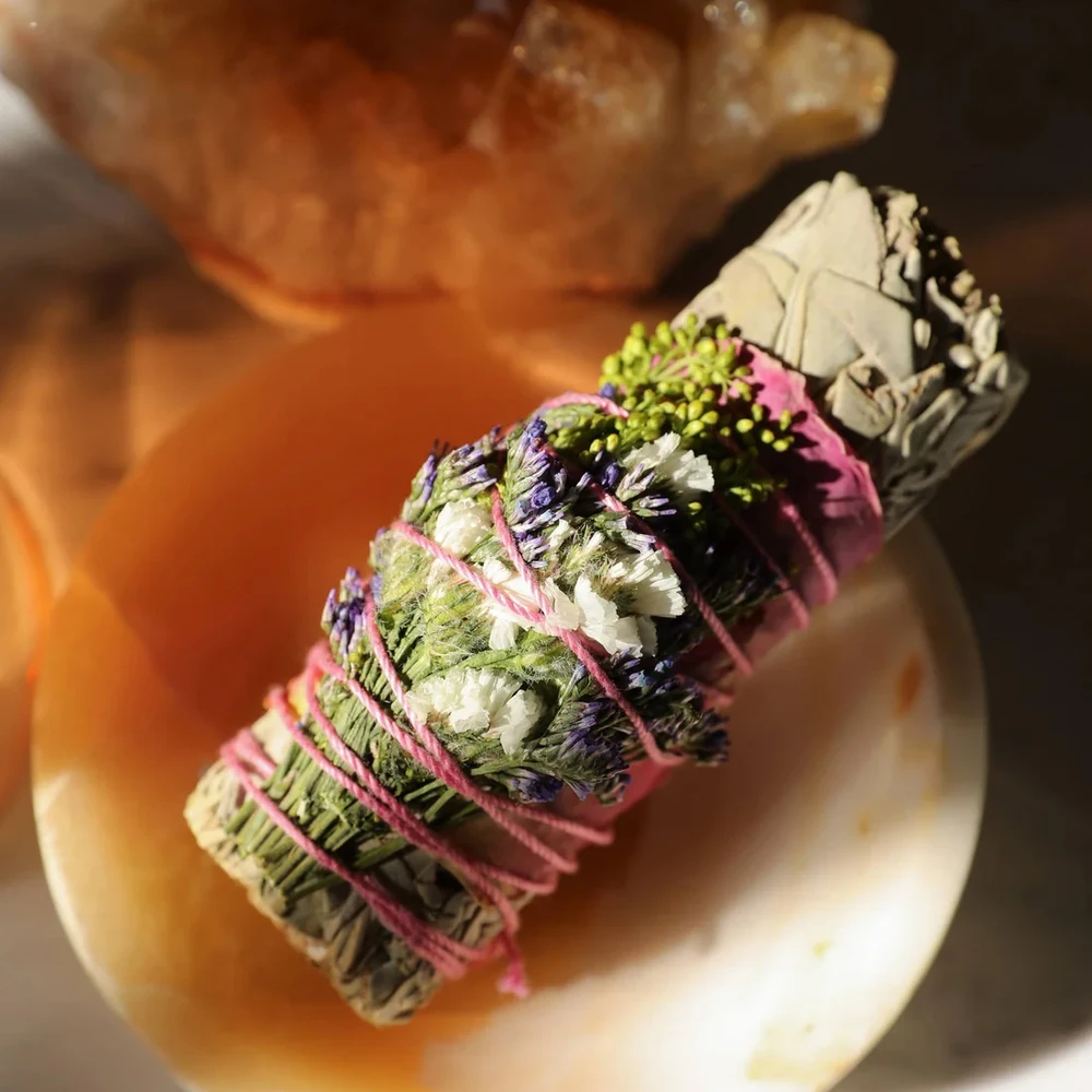 White sage stick adorned with dried wildflowers