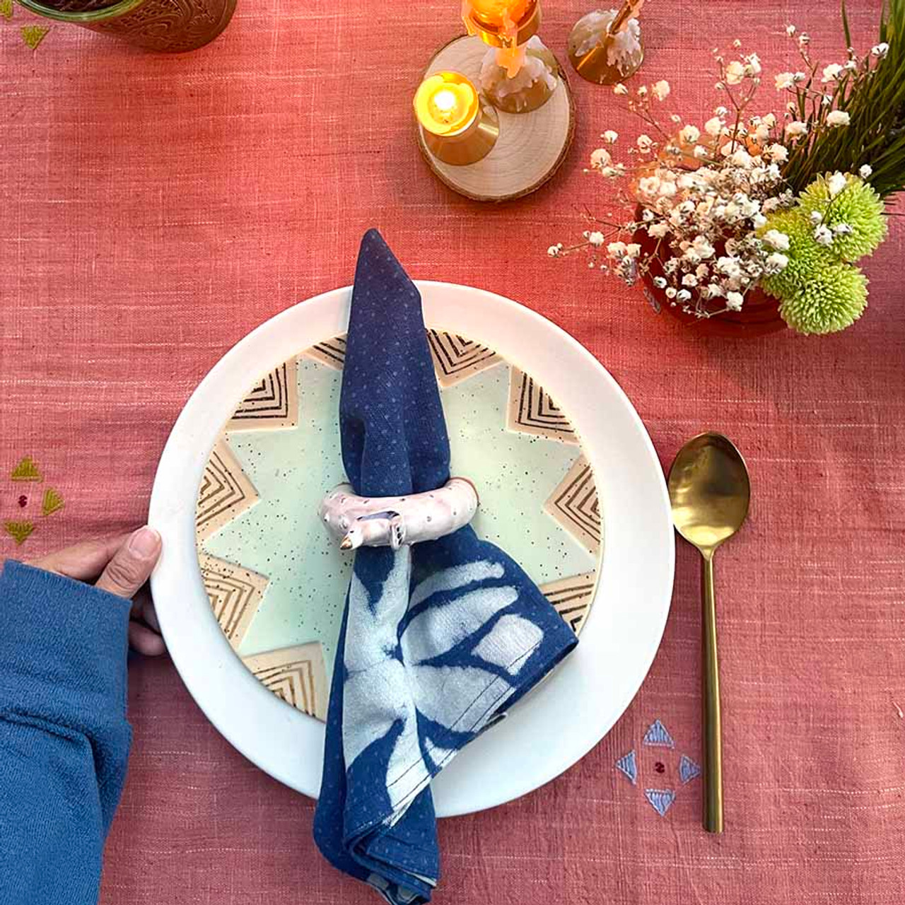 table setting with block print napkin and tablecloth layering napkins with chargers and runners