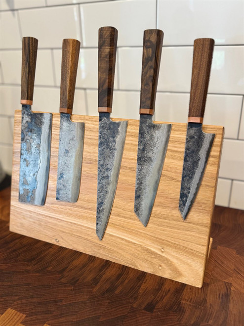 Handmade magnetic knife block in reclaimed Australian hardwood, holding five dark-handled hand-forged knives