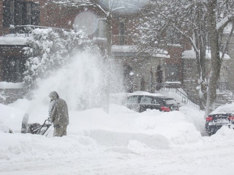 Clearing snow with a snowblower after a winter storm.