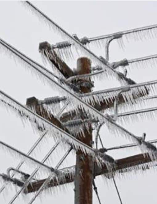 Power lines and utility pole coated by a thick layer of ice and icicles.