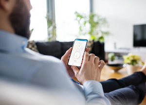 A homeowner monitors his energy use with the PWRview Smart Phone App