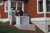An Installers shows a couple their new 20kW 40645 Briggs and Stratton Home Standby Generator outside their home