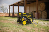 The Champion 7500 Watt Remote Start Generator Outside a Shed with Hay Bales