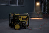 Champion Dual Fuel Generator 7500 Home Backup During A Power Outage. A Man with A Flashlight Inspects the Generator on a Dark Driveway