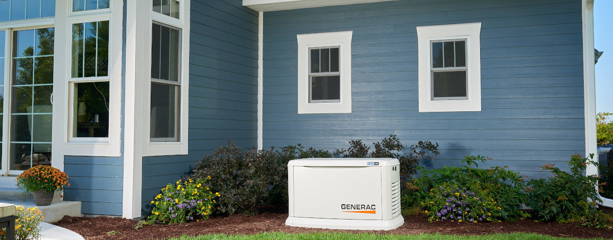 Generac Guardian Generator installed next to a blue two story home with white trim