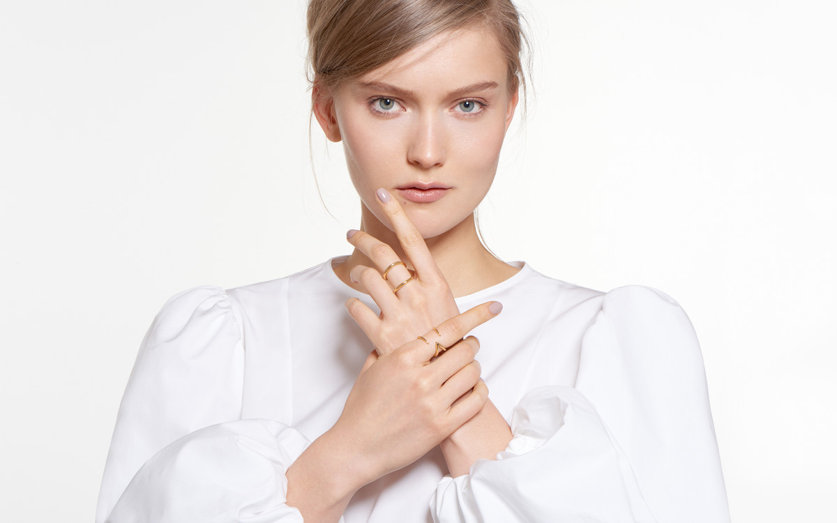 model gazing pensively sporting 18 karat gold ring in horn design