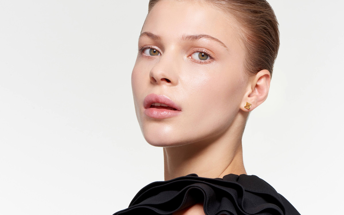 model adorned with burnished satin cage stud earrings in 22 karat gold