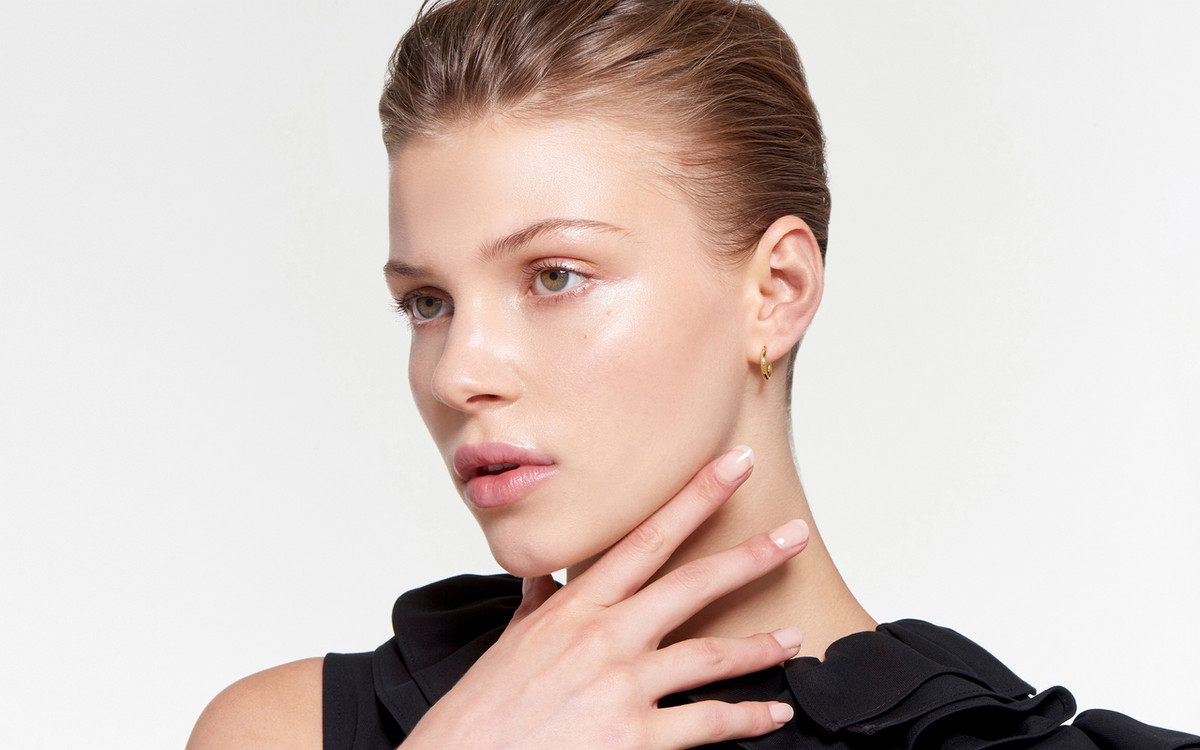 glowing 22 karat gold hoop earrings displayed on striking model