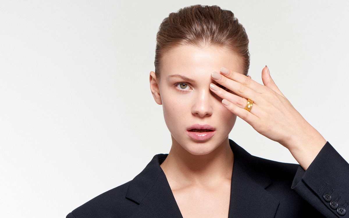 stylish model sporting 22 karat gold stacker-style ring in satin finish