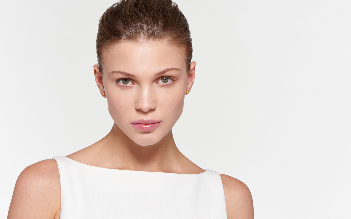 beautiful model wearing burnished stud earrings of 22 karat gold satin finish