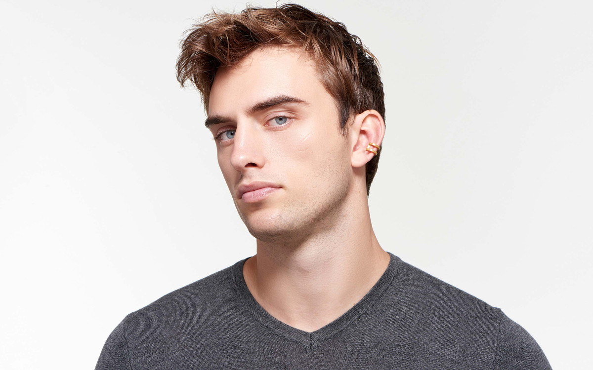 lustrous 22 karat satin gold ear cuff on handsome male model