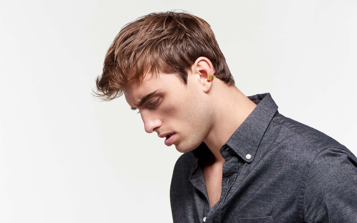 reflective male model with bright 22 karat polished gold ear cuff