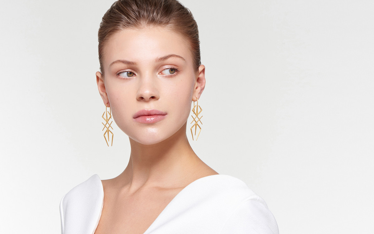 ethereal female model adorned with modish arthropod 22 karat gold earrings