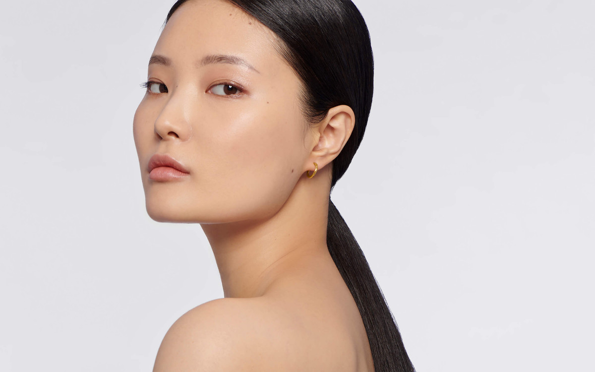 Woman model wearing 22 karat gold earring.