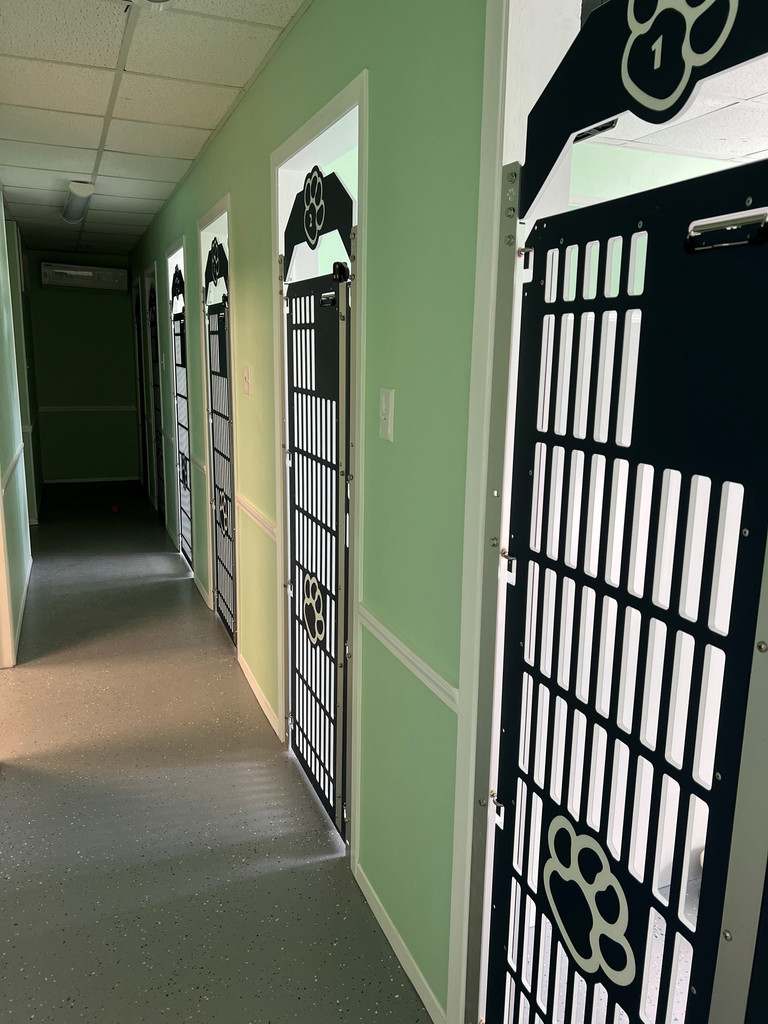 Hill Country Pet Paradise chose our navy blue gates to compliment their mint green walls.They look great and with our easy install design for adding to existing walls, they have a sleek and professional finish. You see that they decided to go with the full-slotted gates to maximize air flow in the kennel rooms and chose our cute paw print for the gate and header. The complimentary clipboard is great for keeping all of the pups information right there with them.
