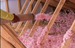 Person installing pink attic installation