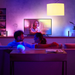 LED Hue bulbs in fixtures with couple on couch watching TV