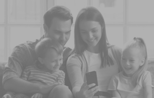 Family looking at phone together and smiling