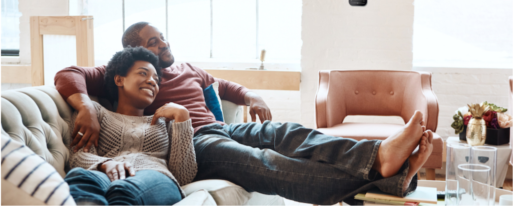 Couple siting on couch with their feet up