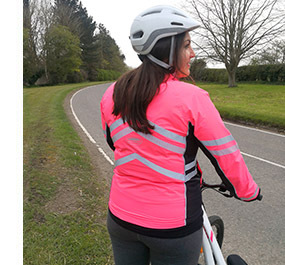 Woman standing by bike in WeatherBeeta Reflective Jacket