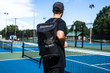 Courtside Pickleball Backpack in Black: Rugged, high-quality pickleball backpack fits 4+ paddles with padded dividers and separate zipper compartment for shoes. Includes additional zipper pockets for keys, phone and other essentials. Comes with two elastic-top mesh pockets for standard size water bottles.