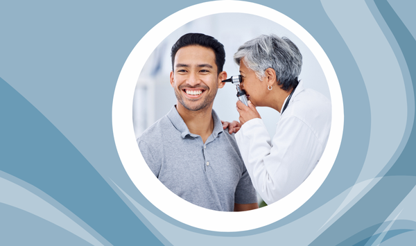 Healthcare professional examining a smiling patient’s ear during a routine ear check