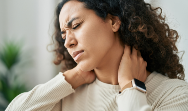 Woman gently holding her neck, representing everyday discomfort and pain relief support.