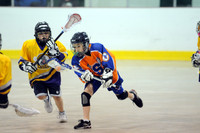 Youth lacrosse player in helmet and pads running with lacrosse stick during outdoor game