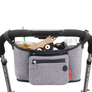 Skip Hop grey stroller organiser with black trim attached to handlebar, holding drinks, toy and accessories with front