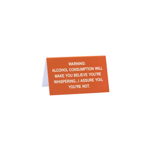 Orange tabletop sign with white text reading humorous alcohol consumption warning, Say What brand desk signage displayed on