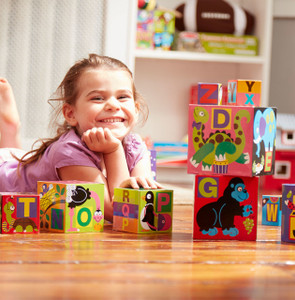 Young girl playing with Melissa & Doug colourful alphabet nesting blocks featuring letters, animals and bright patterns