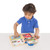 Close-up of toddler hand operating one of the latches on Melissa & Doug Lock & Latch Board