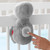 Skip Hop Cry-Activated Soother Sloth attached to cot rail via clip