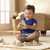 Toddler placing wooden cow piece into Melissa and Doug farm puzzle board