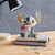 Disney by Britto Midas Stitch figurine holding red flower on stacked notebooks against hex tile backdrop