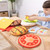 Child carefully placing wooden burger layer in the Melissa and Doug Burger Stacking Game