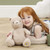 Winnie The Pooh 100th Anniversary Commemorative Soft Toy 19cm - scale shot showing 19cm plush against hand for size reference | Peekaboobaby