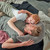 Theraline Plushy Moon Taupe - father and child cuddling together on bed with moon-shaped pillow for comfort and bonding