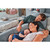 Family with newborn using mid-grey Theraline maternity pillow on bed in styled bedroom setting