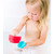Young child bathing while playing with individual Ubbi Lighthouse red and turquoise cups