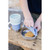 Child's hands holding open Beaba meal box compartment with crackers outdoors