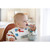 Toddler eating from white bowl using Beaba pre-cutlery fork in kitchen