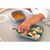 Close-up of child's hand holding Beaba fork with food on mint plate