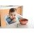 Baby using Beaba terracotta pre-spoon with parent, coral bowl nearby