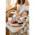 Caregiver feeding infant from Beaba clay sippy cup in warm home setting