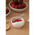 Beaba pink spoon in white bowl with strawberries, crackers and milk cup