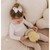 Toddler holding Bubble Bumble the Bee plush toy indoors