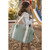 Child wearing Beaba Paris grey changing bag with cream straps at playground