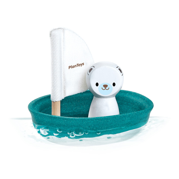 PlanToys wooden sailing boat bath toy with white polar bear figurine and teal hull floating in water